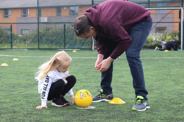 Young girl and instructor talking about football