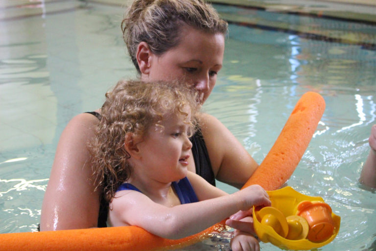 Physioterapist in Hydrotherapy pool with young child