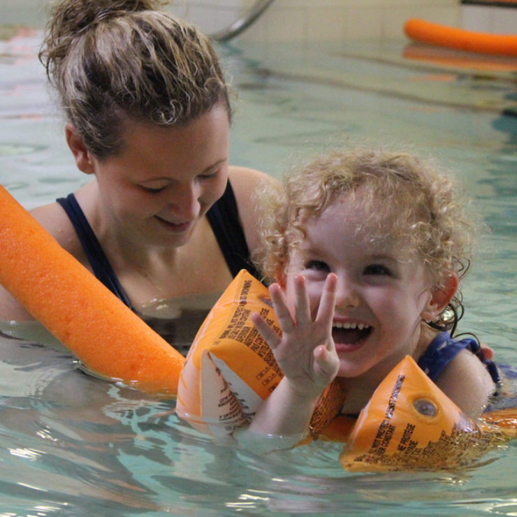 Physioterapist in Hydrotherapy pool with young child