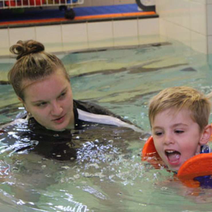 Young boy learning to swim