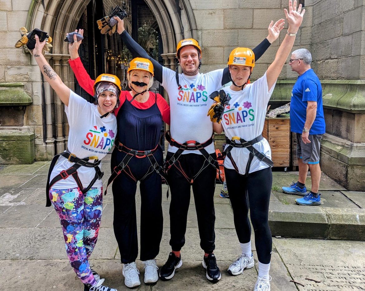 Group of SNAPS fundraIsers wearing harnesses for abseiling