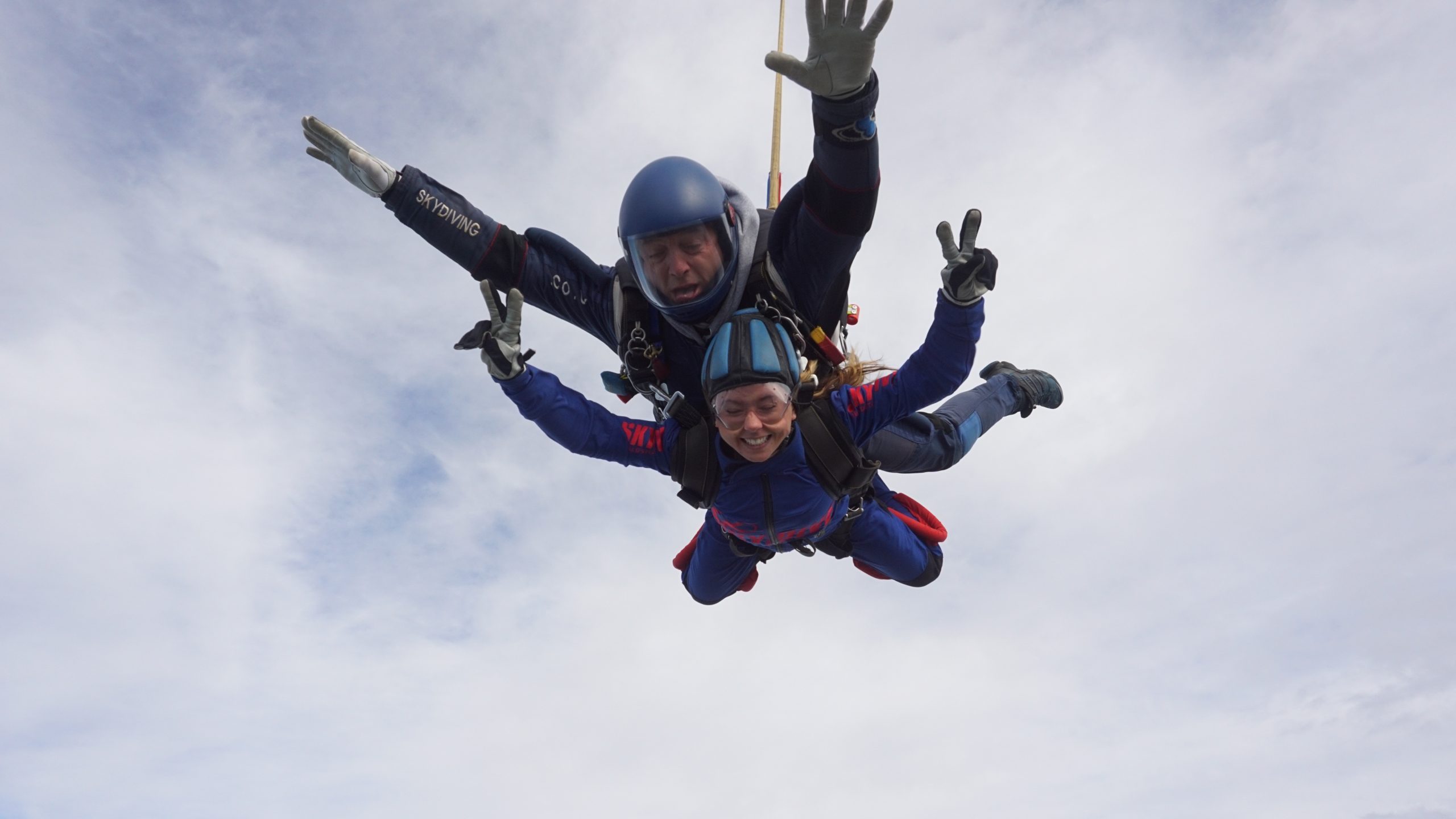 Two people taking part in a tandem skydive in the air